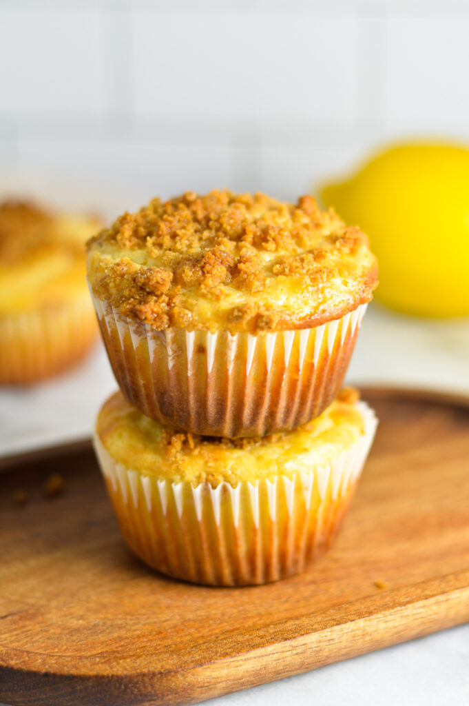 Two Lemon Muffins stacked with a lemon in the background.