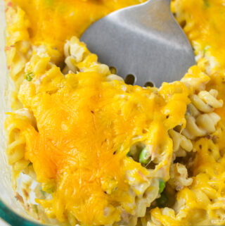 A large glass baking dish with a spatula scooping some Tuna Casserole.