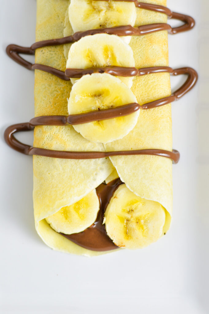 A crepe filled with Nutella and bananas with more Nutella drizzled on top.