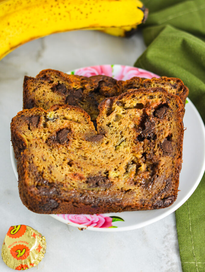 Peanut Butter Cup Banana Bread with ripe bananas and Mini Reese's peanut butter cups in the background.