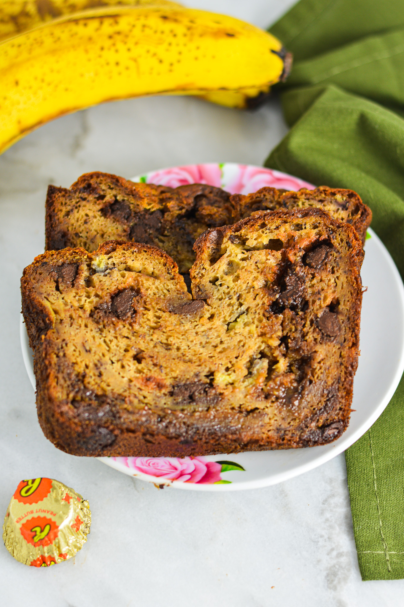 Peanut Butter Cup Banana Bread with ripe bananas and Mini Reese's peanut butter cups in the background.