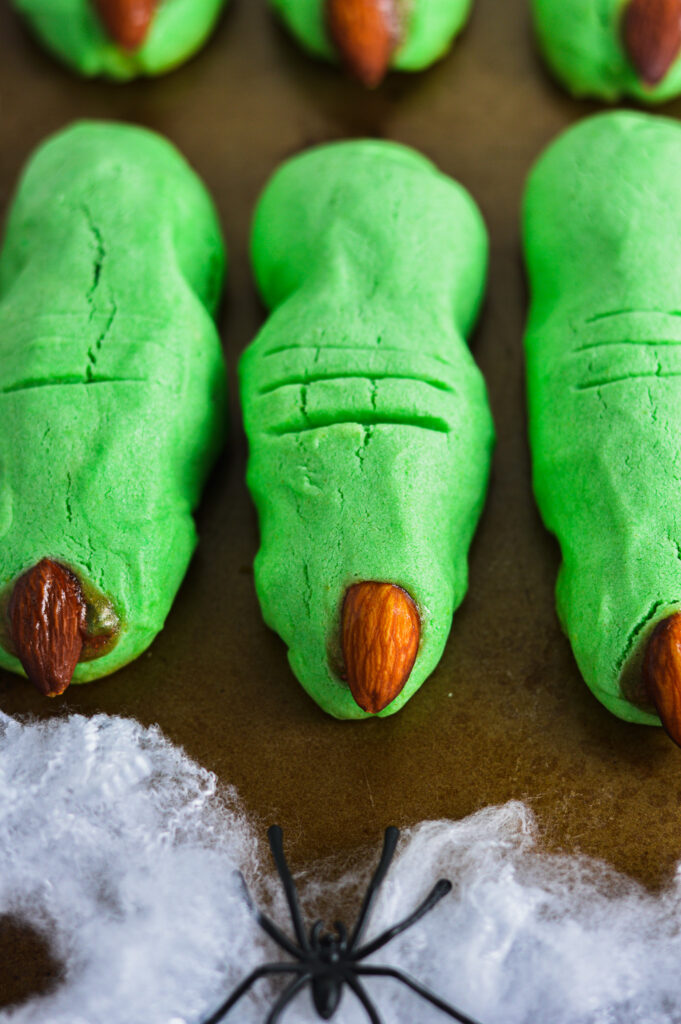 Witch Finger Cookies on a cookie sheet with a spider in a spiderweb.