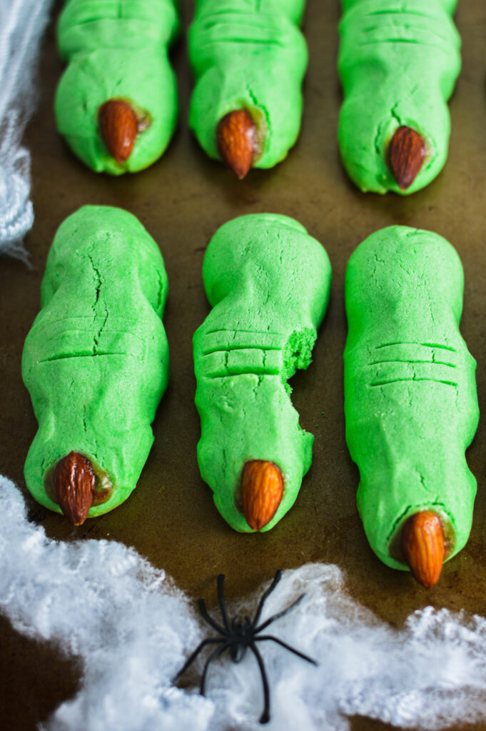 Green Witch Finger Cookies with a bite taken out of the middle cookie.