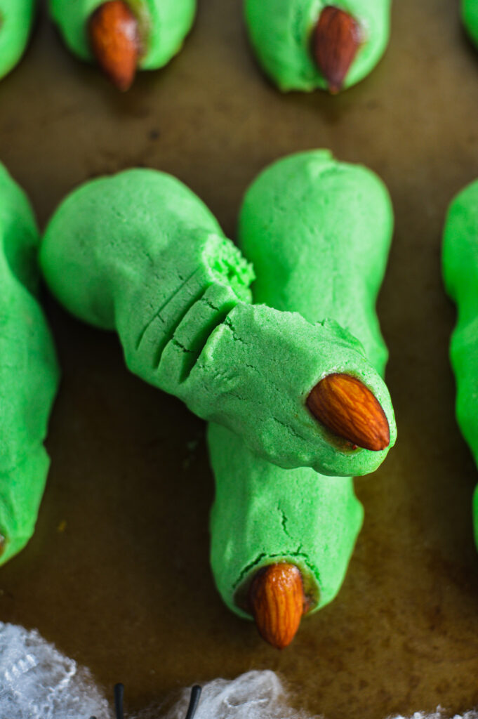 Spooky Witch Finger Cookies with a bite taken out of the knuckle.