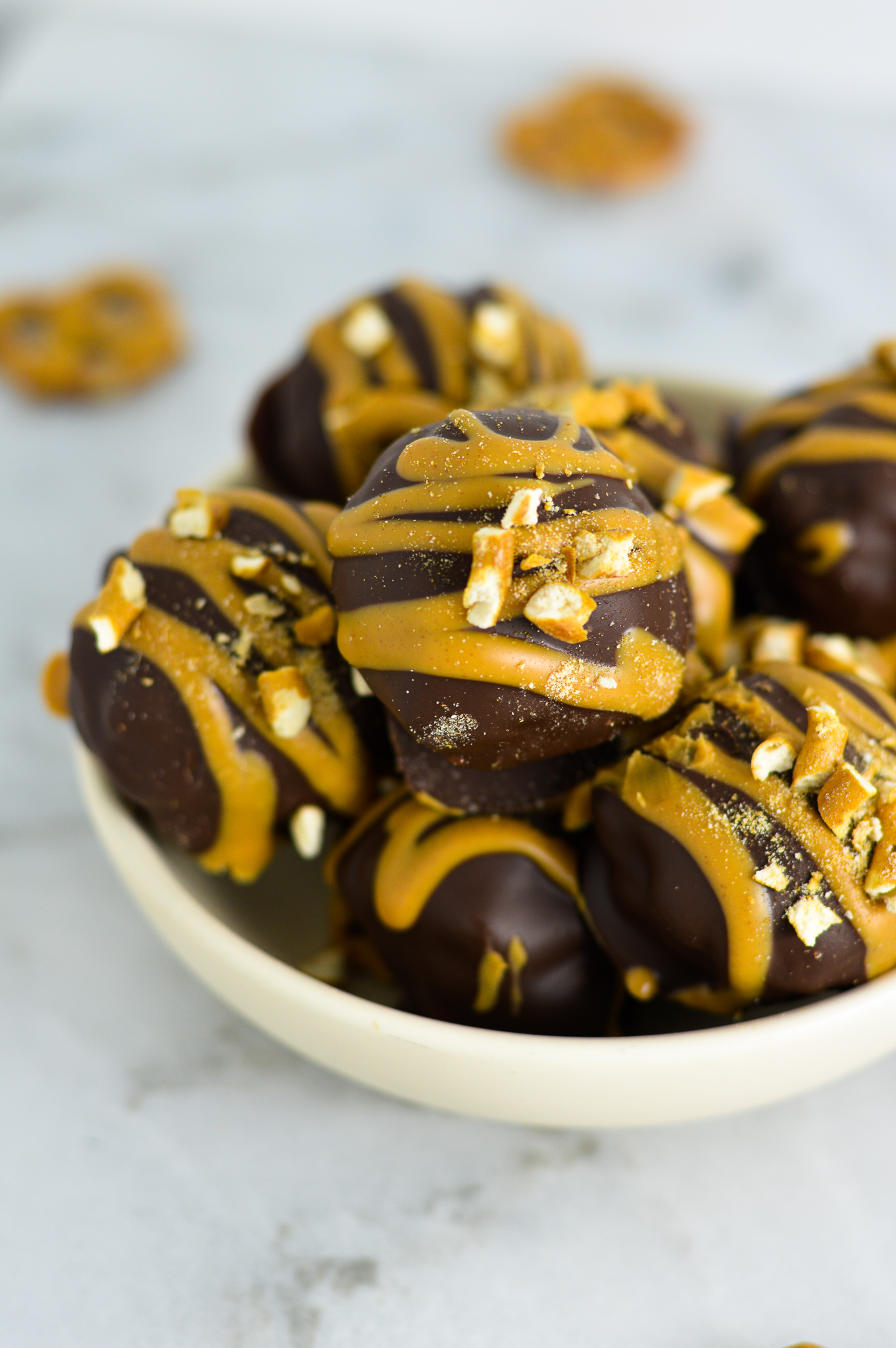 Peanut Butter Pretzel Truffles on a shallow white plate.