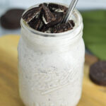 An Oreo Milkshake in a mason jar with crushed Oreo on top.