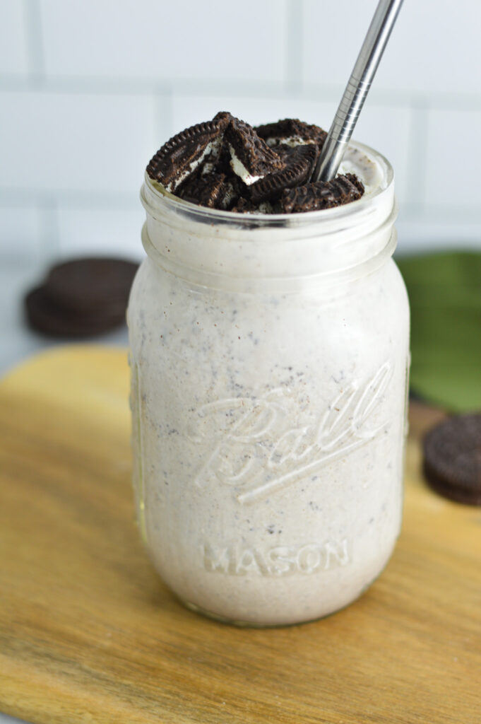 Oreo Milkshake in a glass mason jar with a metal straw in it.