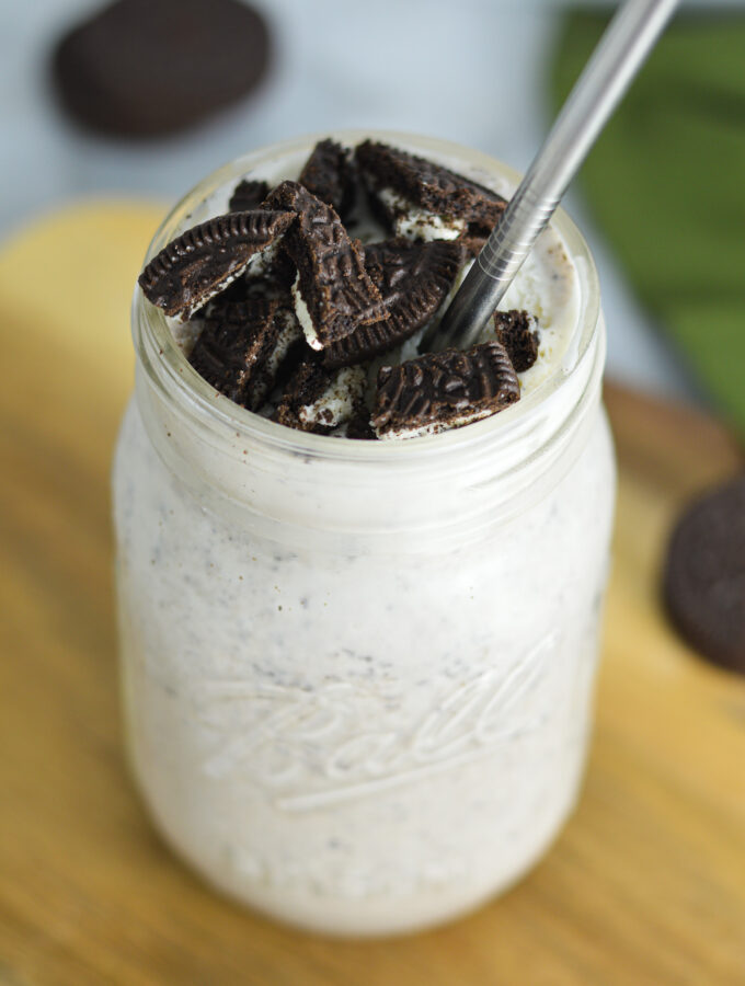 Oreo Milkshake with Oreo pieces on top and a straight metal straw in it.