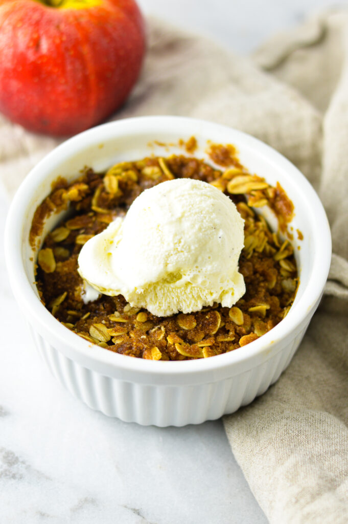 5 Minute Apple Crisp for One with a scoop of vanilla bean ice cream on top.