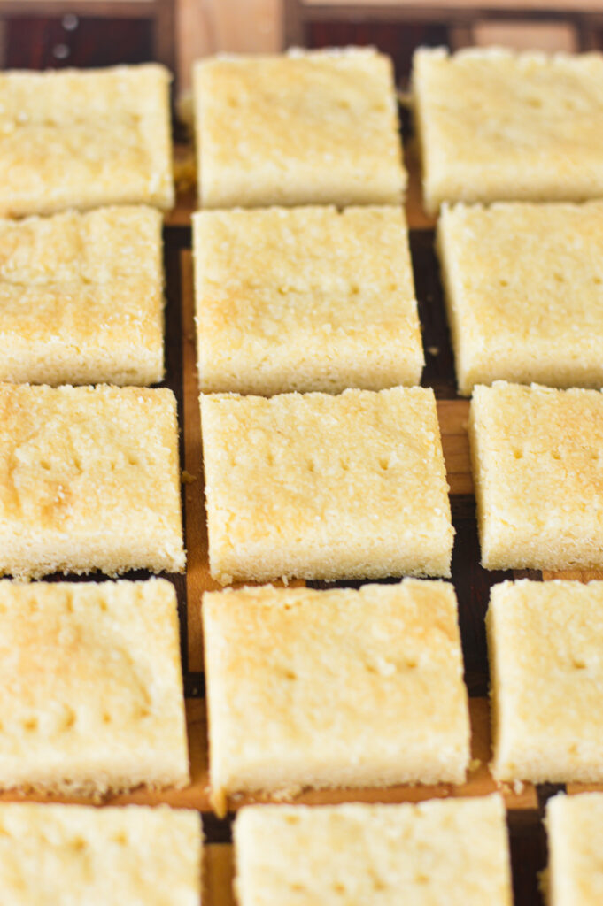 Shortbread Cookies lined neatly on a wooden cutting board.