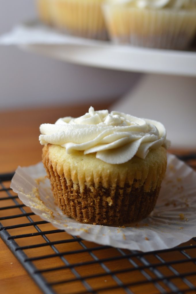 Super moist vanilla cupcakes with vanilla frosting. A surprise cookie is baked on the bottom of the cupcakes to make them extra special.