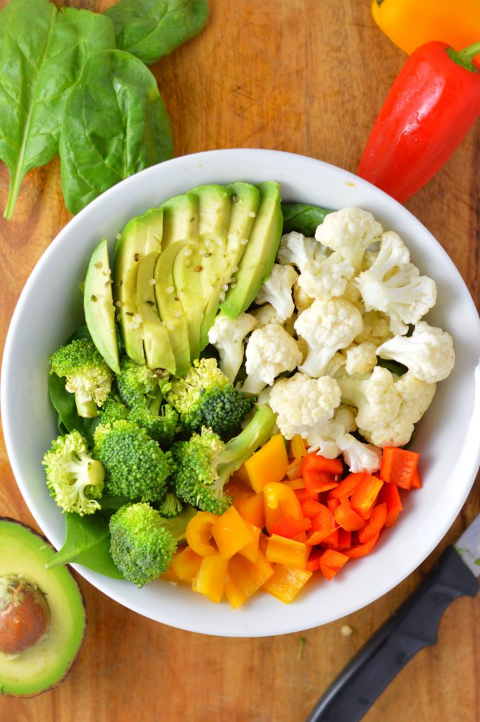 Super simple Veggie Buddha Bowl made with spinach, cauliflower, broccoli, bell peppers and, of course, avocado. Perfect for lunch or dinner.