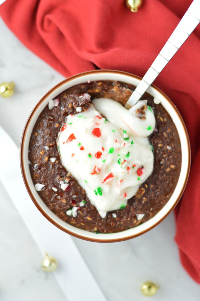 Peppermint Mocha Oatmeal makes for a warm and comforting breakfast recipe for the holidays. topped with yogurt and crushed candy canes.