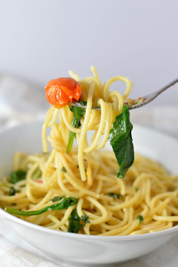 Healthy Spinach and Cherry Tomato Spaghetti. This pasta recipe is vegan and ready in under 30 minutes. Perfect for a quick and easy weeknight dinner idea.