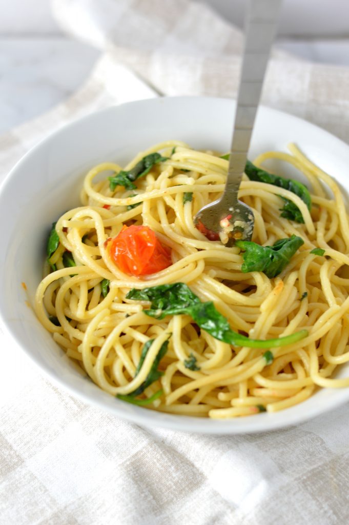 Healthy Spinach and Cherry Tomato Spaghetti. This pasta recipe is vegan and ready in under 30 minutes. Perfect for a quick and easy weeknight dinner idea.