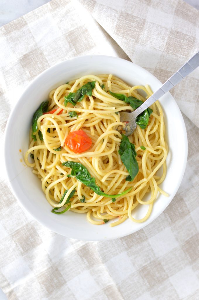 Healthy Spinach and Cherry Tomato Spaghetti. This pasta recipe is vegan and ready in under 30 minutes. Perfect for a quick and easy weeknight dinner idea.