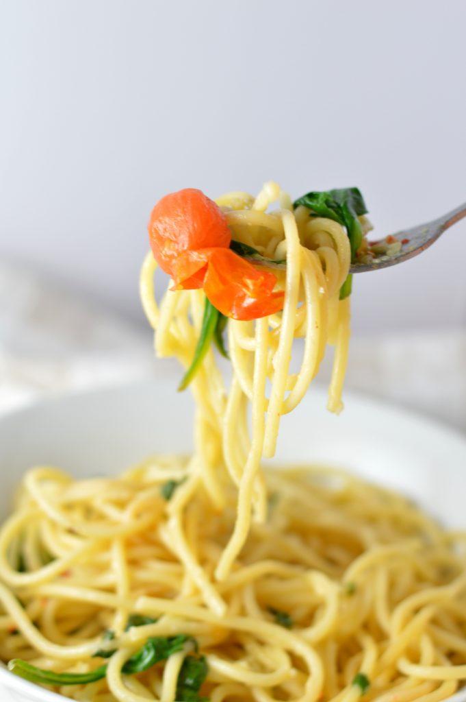 Healthy Spinach and Cherry Tomato Spaghetti. This pasta recipe is vegan and ready in under 30 minutes. Perfect for a quick and easy weeknight dinner idea.