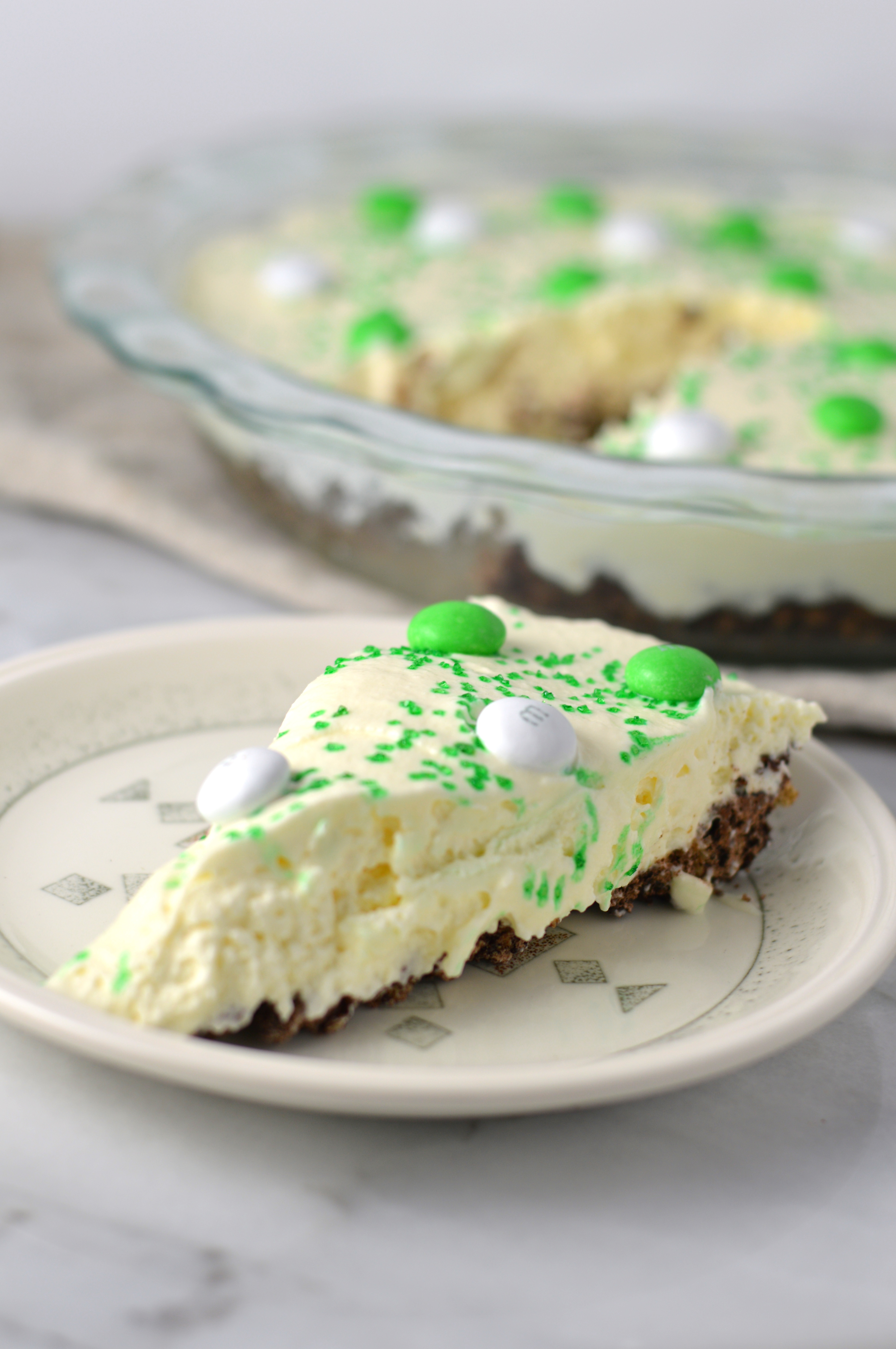 Easy St Patrick's Day Ice Cream Cake recipe. Made with prepared ice cream, weetabix and mint m&ms, this makes a great last minute dessert idea.