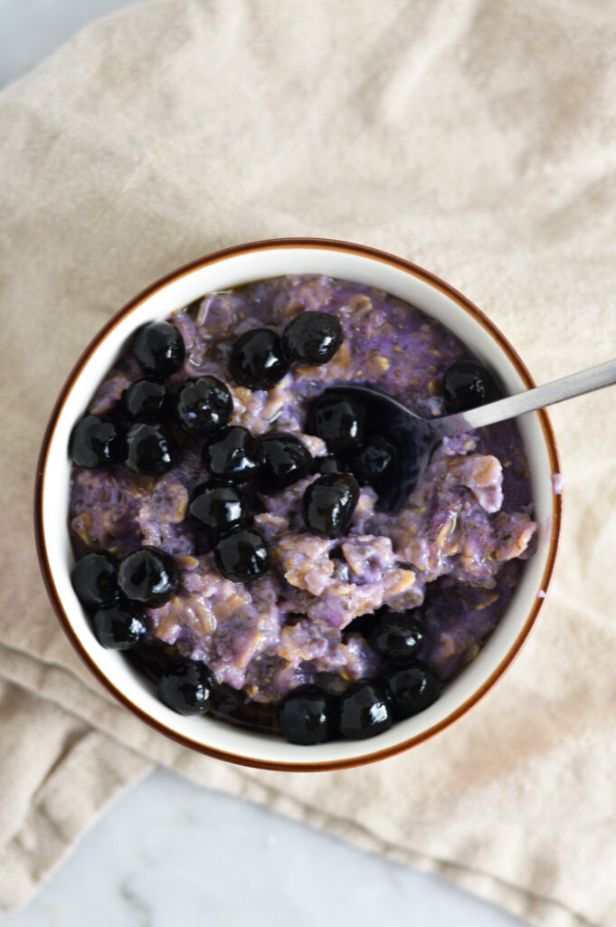 A spoon in a small bowl of Taro Bubble Tea Oatmeal