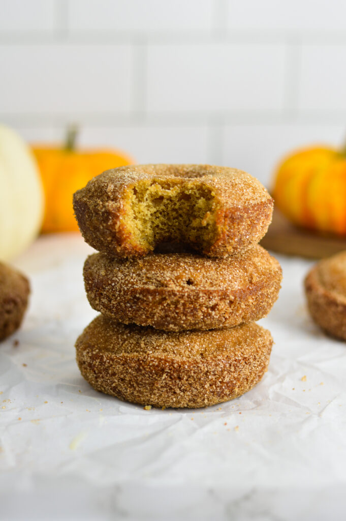 Apple Cider Baked Donuts stacked on a granite surface.