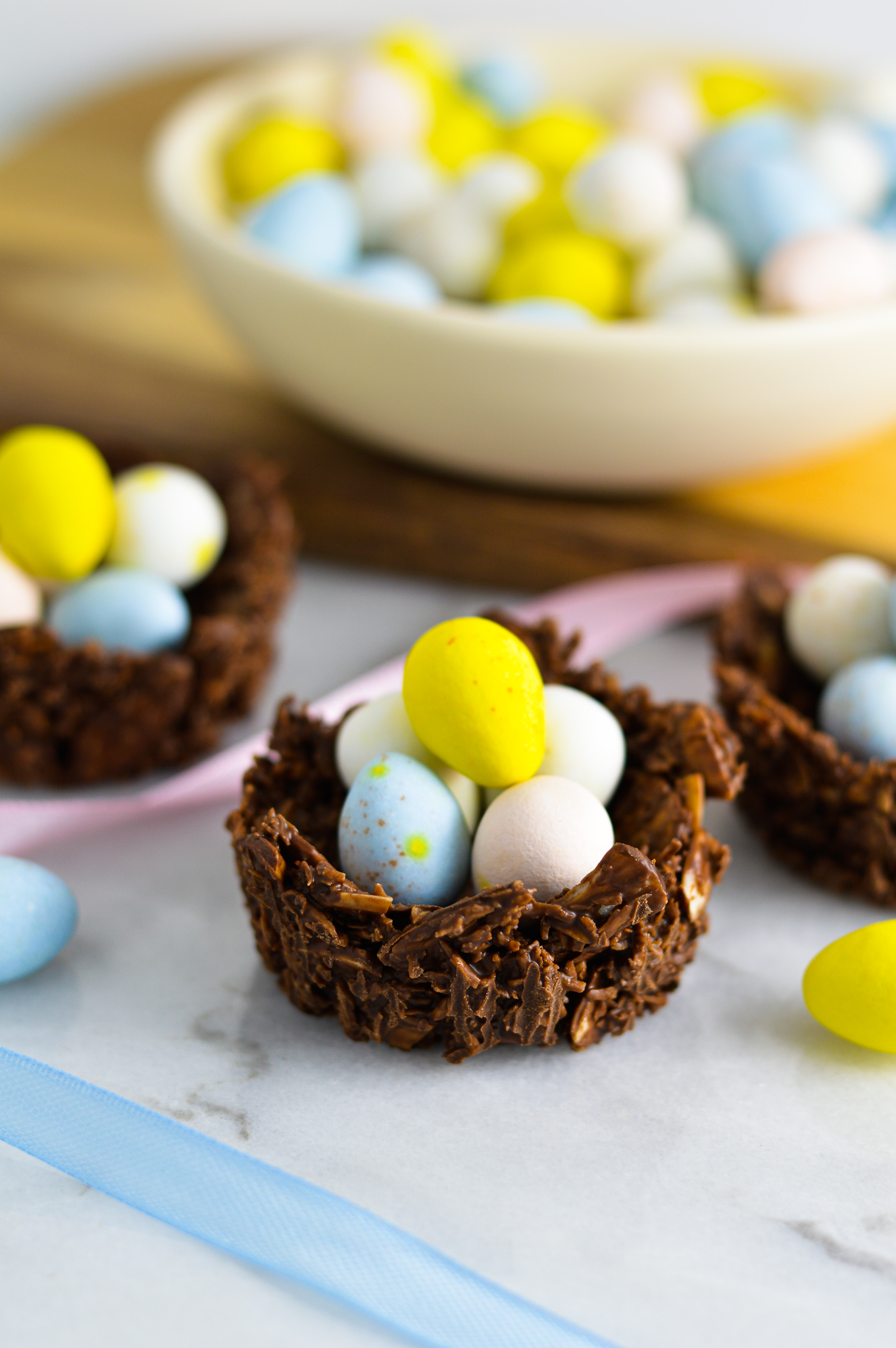 Almond Joy Easter Egg Nests with Mini Eggs and pastel ribbons beside them.