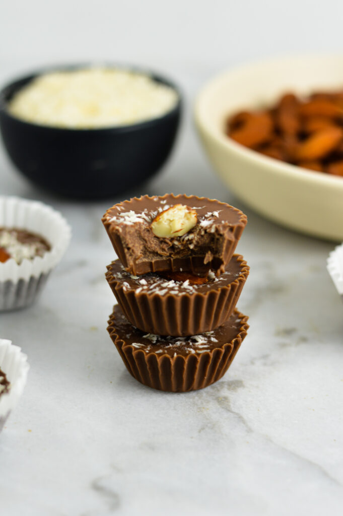 3 Almond Joy Nutella Cups stacked with a bite taken out of the top chocolate cup.