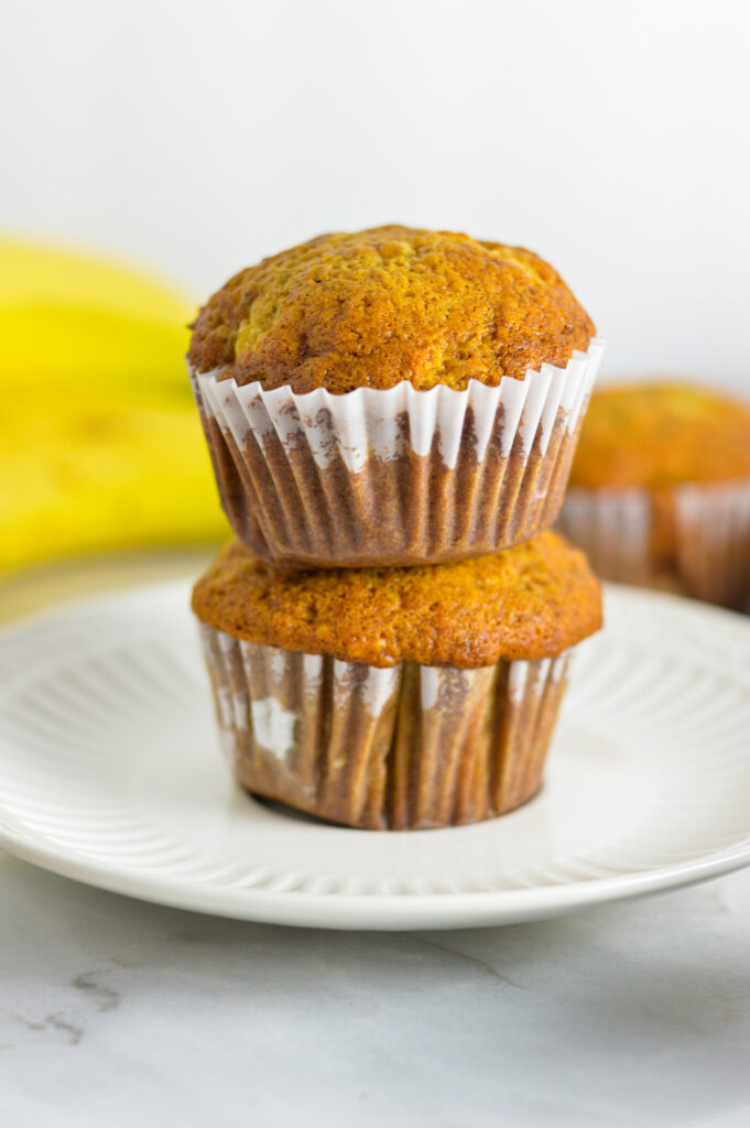 A stack of moist Banana Muffins on a small white plate.