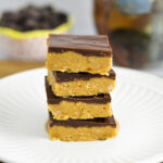 4 Chocolate Peanut Butter Squares stacked on a white plate.