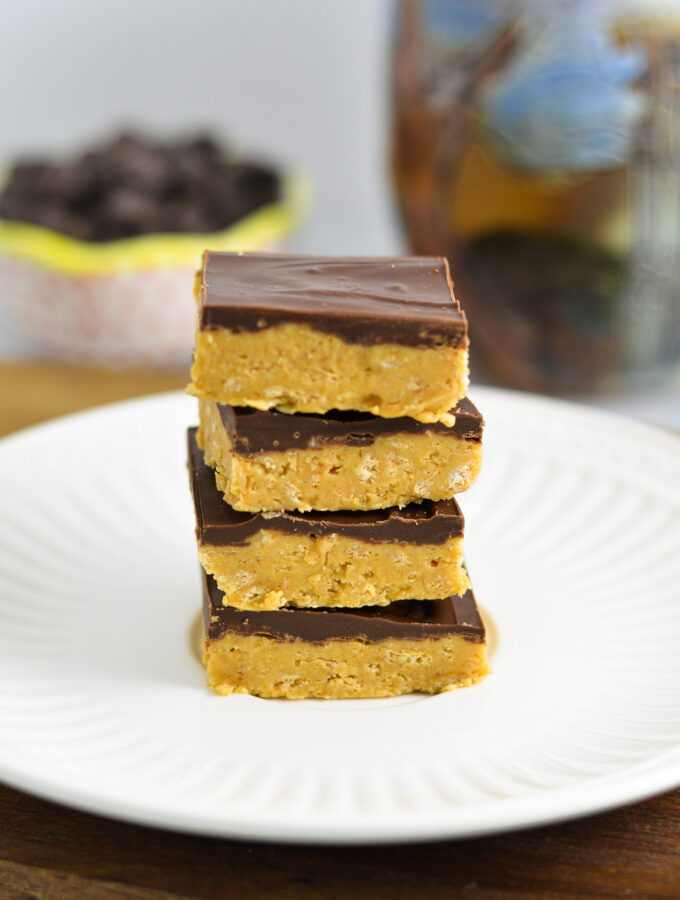 4 Chocolate Peanut Butter Squares stacked on a white plate.