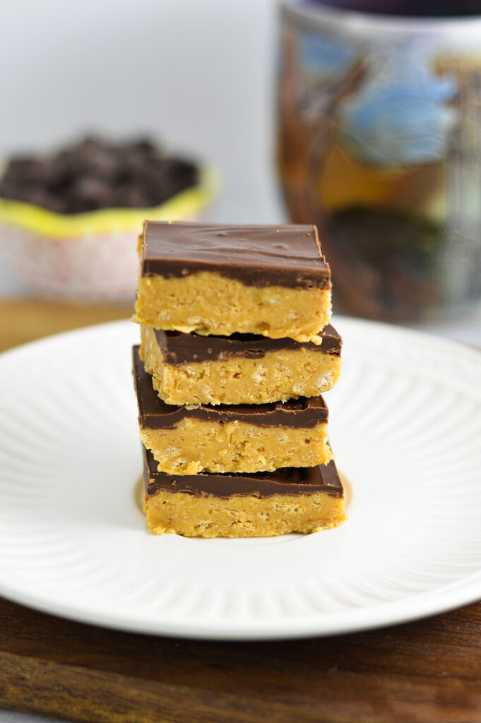 4 Chocolate Peanut Butter Squares stacked on a white plate.