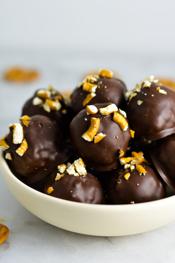 A shallow bowl filled with Crunchy Peanut Butter Pretzel Truffles.