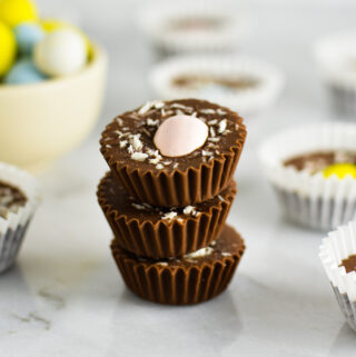 Three Coconut Mini Egg Nutella Cups stacked with more in the background as well as some chocolate Easter eggs.