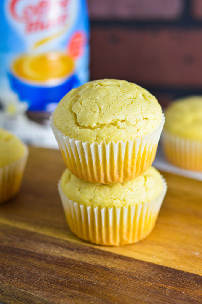 Two Vanilla Creamer Muffins with a bottle of coffee mate creamer in the background.