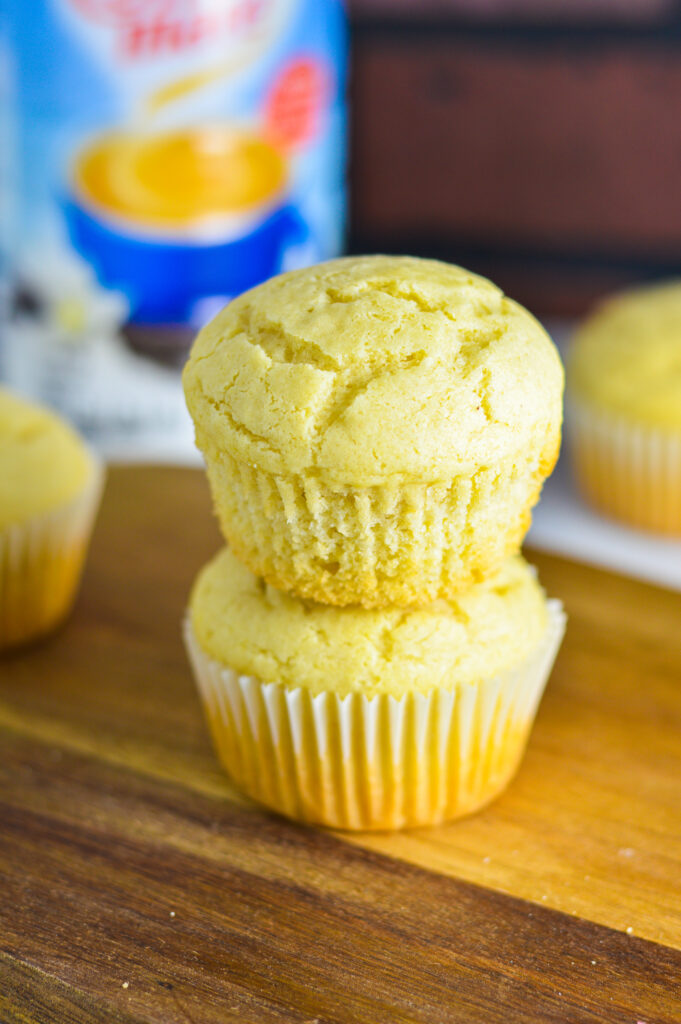 Vanilla Creamer Muffins on a wooden surface with a bottle of French vanilla creamer in the background.