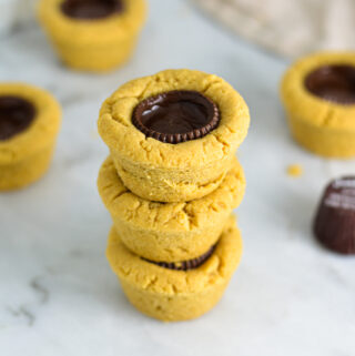 Some Dark Chocolate Peanut Butter Cookie Cups stacked with Justin's mini peanut butter cups in the background.