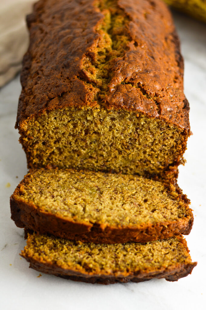 A loaf of Ginger Banana Bread with two slices cut off.