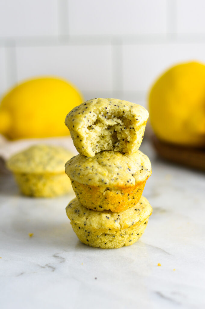 Three Mini Lemon Poppy Seed Muffins stacked with a bite taken out of the top muffin.