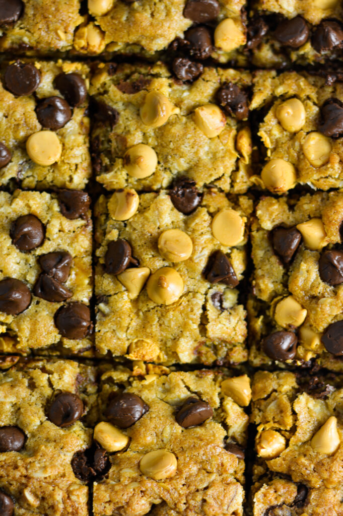 An overhead view of Oatmeal Butterscotch Chocolate Chip Cookie Bars cut into squares in a baking pan.