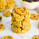 A stack of Chubby Hubby Cookies with a small bowl of chocolate chips in the background.