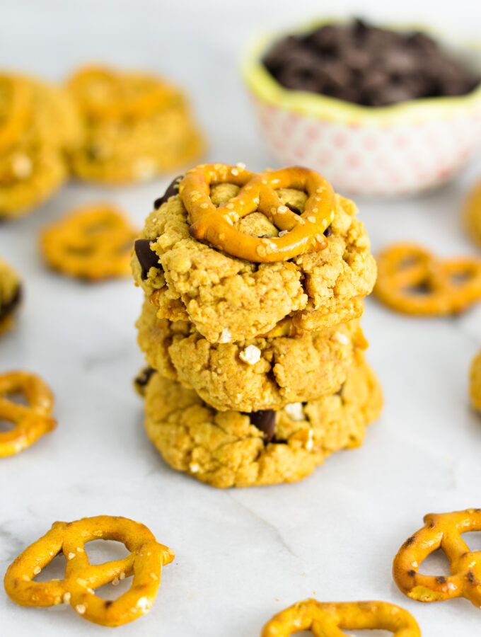 A stack of Chubby Hubby Cookies with a small bowl of chocolate chips in the background.