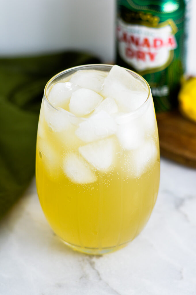 Sparkling Ginger Lemonade with ginger ale and a lemon in the background.