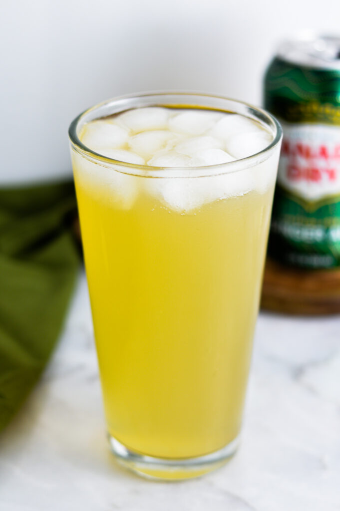 Sparkling Ginger Lemonade in a tall glass with a can of Canada Dry in the background.