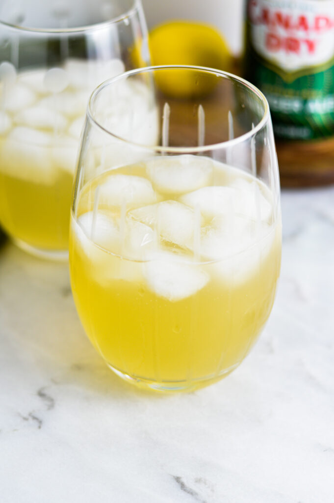 Two small glasses half full with Sparkling Ginger Lemonade.