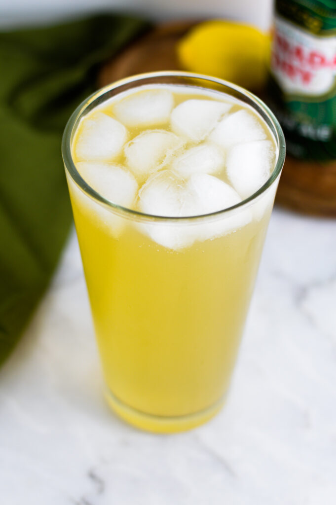 A highball glass with Sparkling Ginger Lemonade and ice in it.