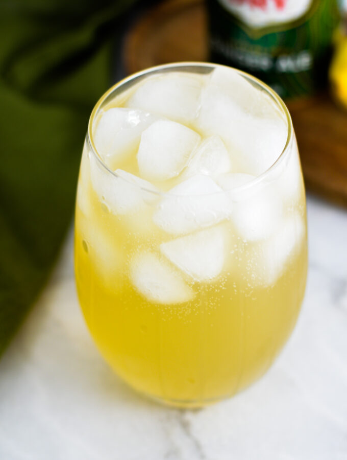 An ice filled glass with Sparkling Ginger Lemonade in it.