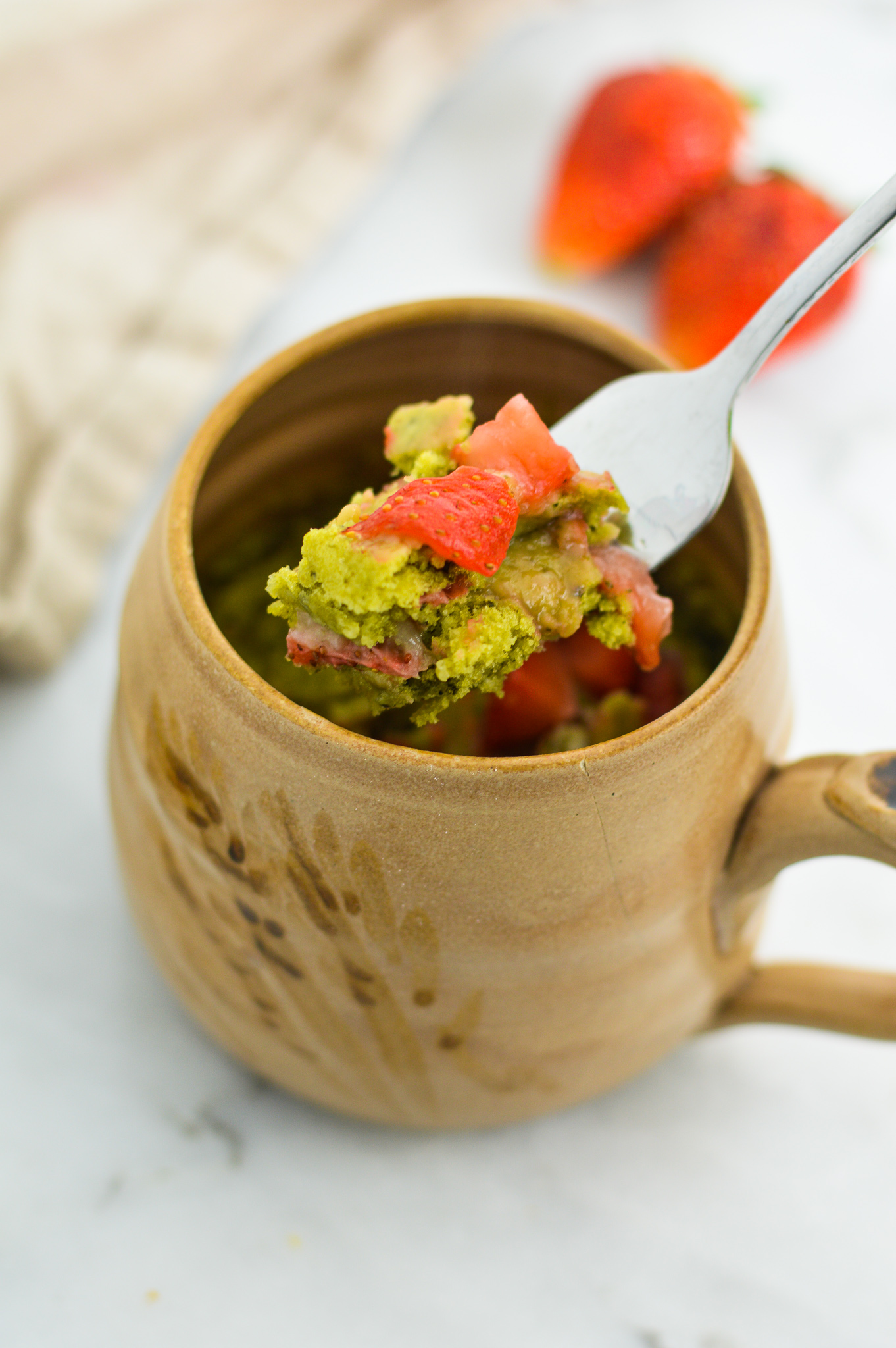 A fork with some Strawberry Matcha Mug Cake on it.