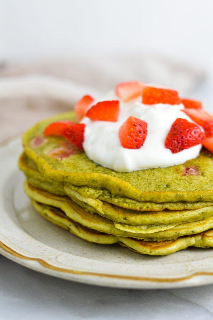 A stack of Strawberry Matcha Pancakes on a small plate.