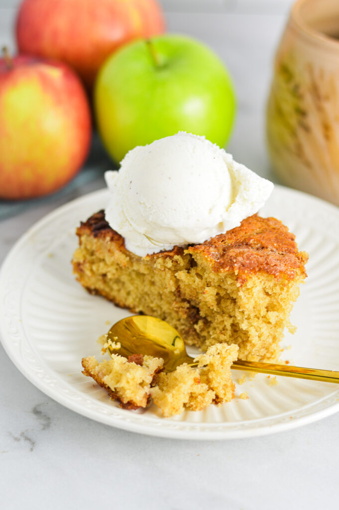 A slice of Dutch Apple Cake with vanilla bean ice cream on top.