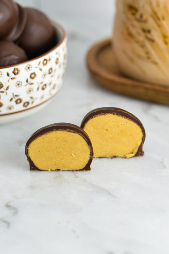 A Peanut Butter Truffle cut in half with a cup of coffee in the background.