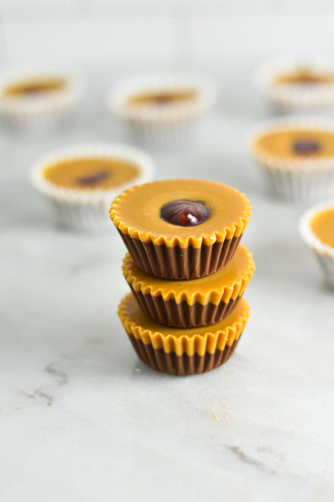 A stack of Peanut Butter and Jelly Nutella Cups with more in mini muffin liners in the background.